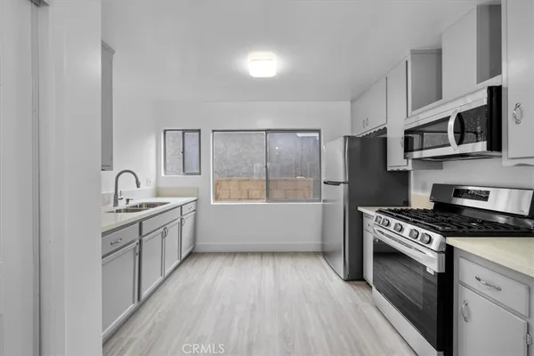 a kitchen with granite countertop a sink cabinets and stainless steel appliances
