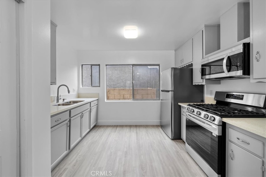 853 West 23rd Street, Unit 2 San Pedro, CA 90731 - Photo 10 of 19 a kitchen with granite countertop a sink cabinets and stainless steel appliances