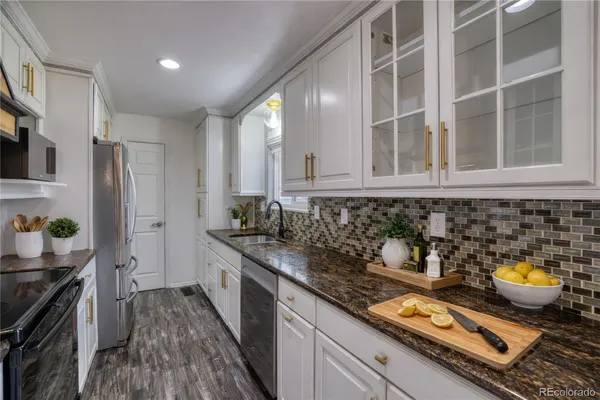 a kitchen with stainless steel appliances granite countertop a stove a sink and a refrigerator