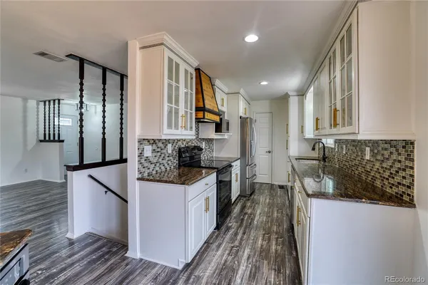 a kitchen with stainless steel appliances granite countertop a sink stove and refrigerator