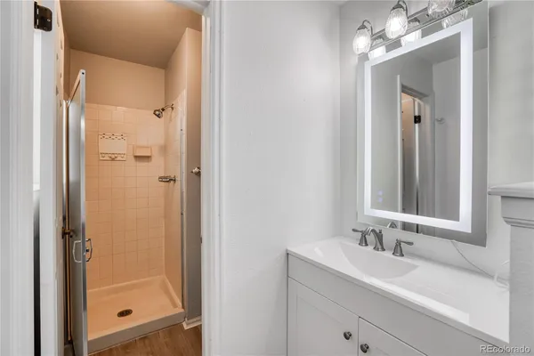 a bathroom with a shower sink and mirror