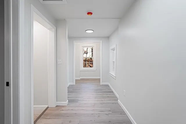a view of a hallway with wooden floor