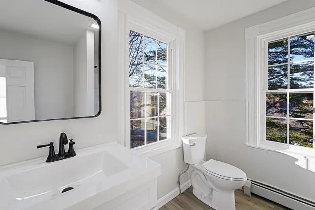a bathroom with a sink a toilet and a window