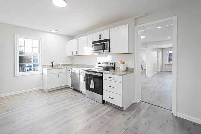 a kitchen with stainless steel appliances a sink cabinets and a window
