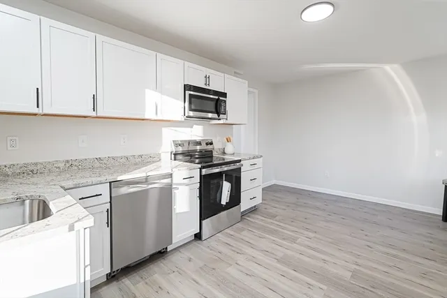 a kitchen with stainless steel appliances granite countertop a stove a sink and a microwave