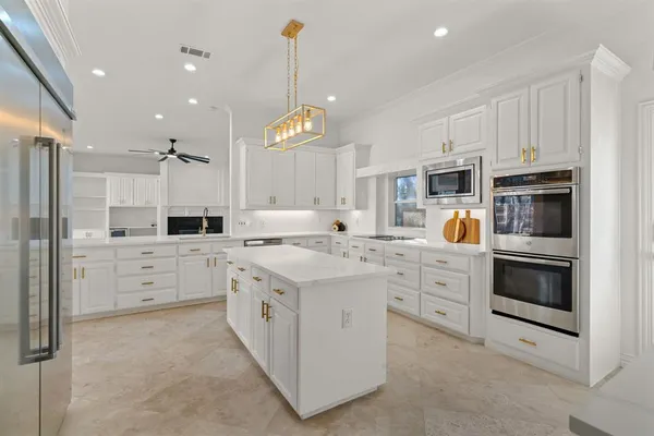 a kitchen with white cabinets and stainless steel appliances