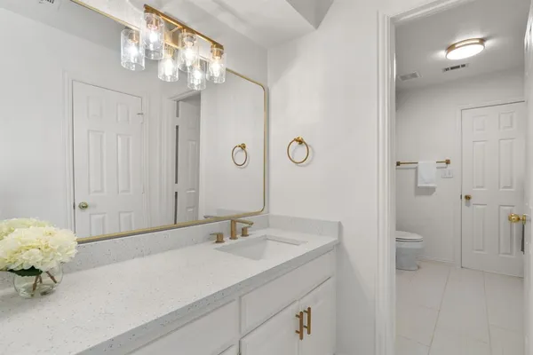 a bathroom with a sink a light fixture and a mirror