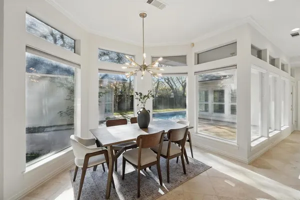 a dining room with furniture a chandelier and window