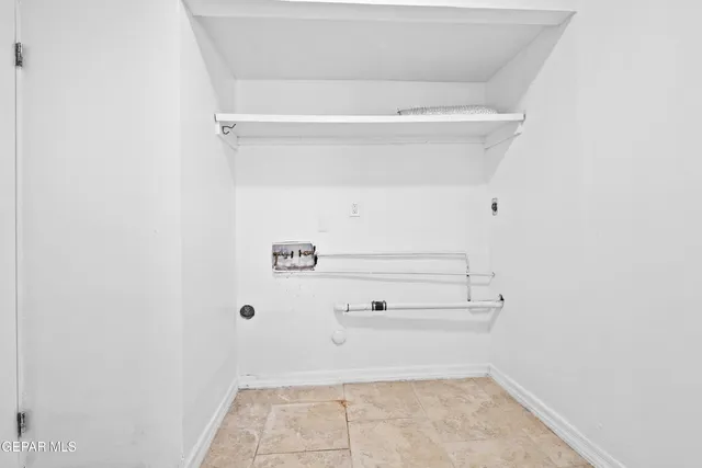 a view of an empty room with closet and utility room
