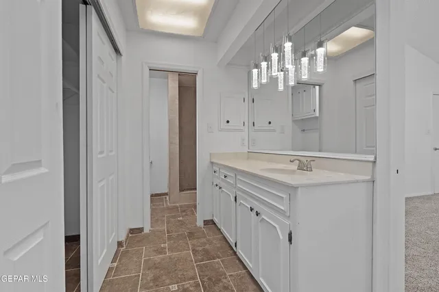 a bathroom with a granite countertop toilet a sink and a mirror