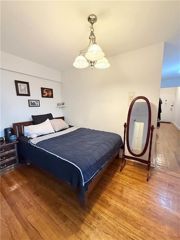 9511 Shore Road, Unit 617 Brooklyn, NY 11209 - Photo 7 of 14 a bedroom with a bed and a chandelier