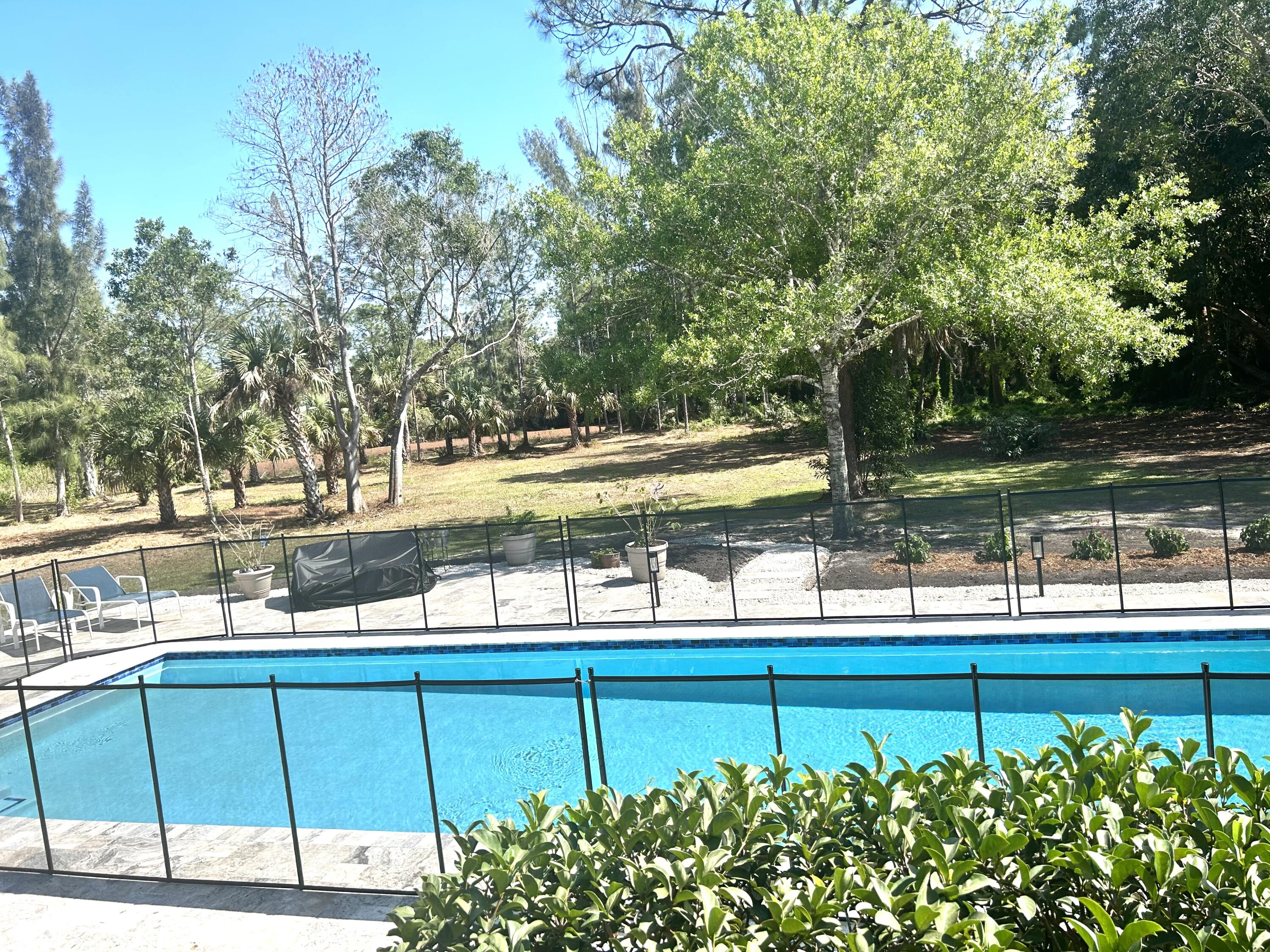 17534 103rd Terrace North Jupiter, FL 33478 - Photo 22 of 25 a view of a lake with a bench and trees in the background