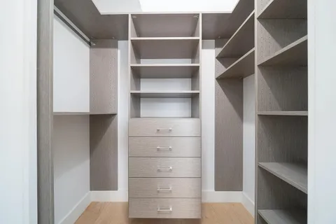 a view of walk in closet with empty racks