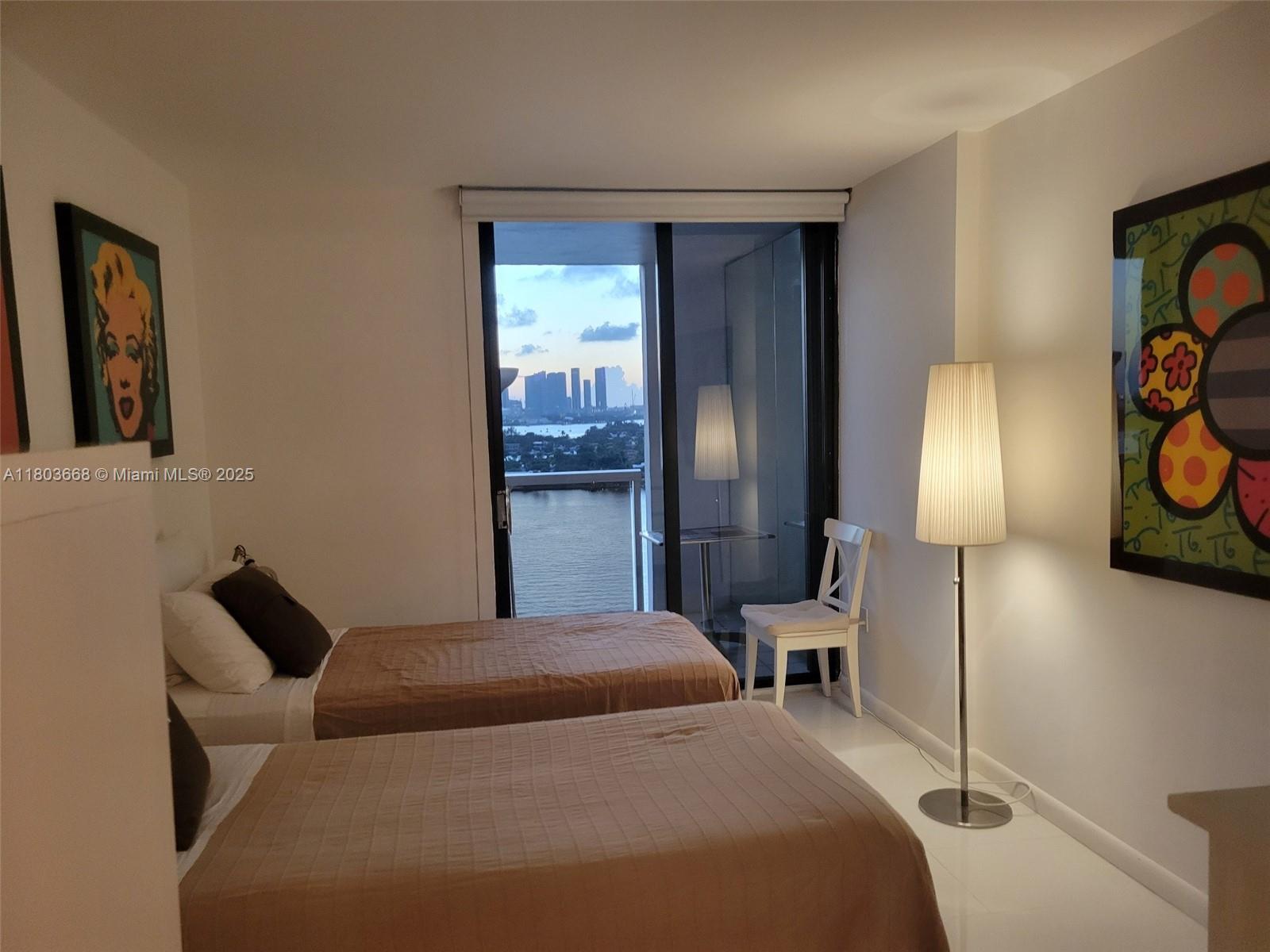 9 Island Avenue, Unit 1806 Miami Beach, FL 33139 - Photo 6 of 21 a bedroom with a bed and lamp