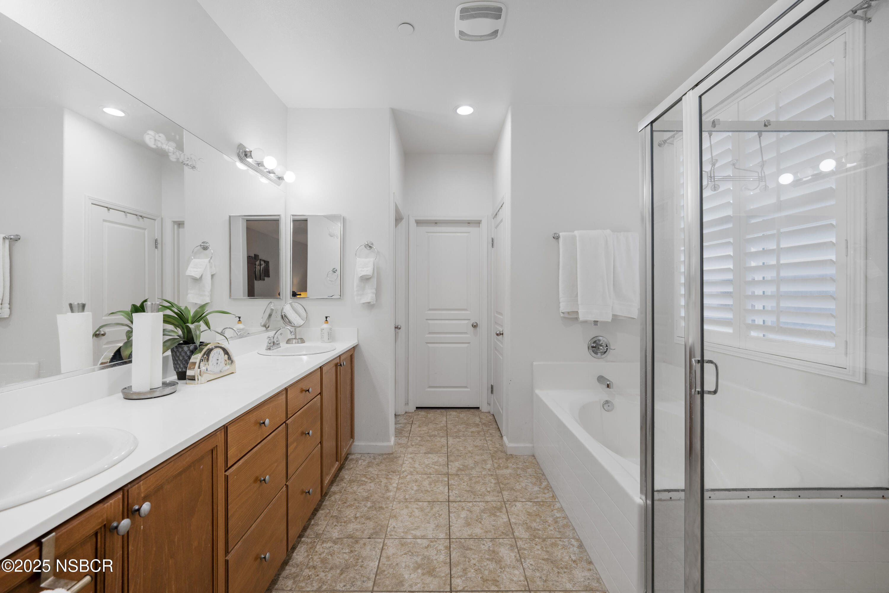1033 Conception Drive Lompoc, CA 93436 - Photo 12 of 18 a bathroom with a double vanity sink and mirror with shower