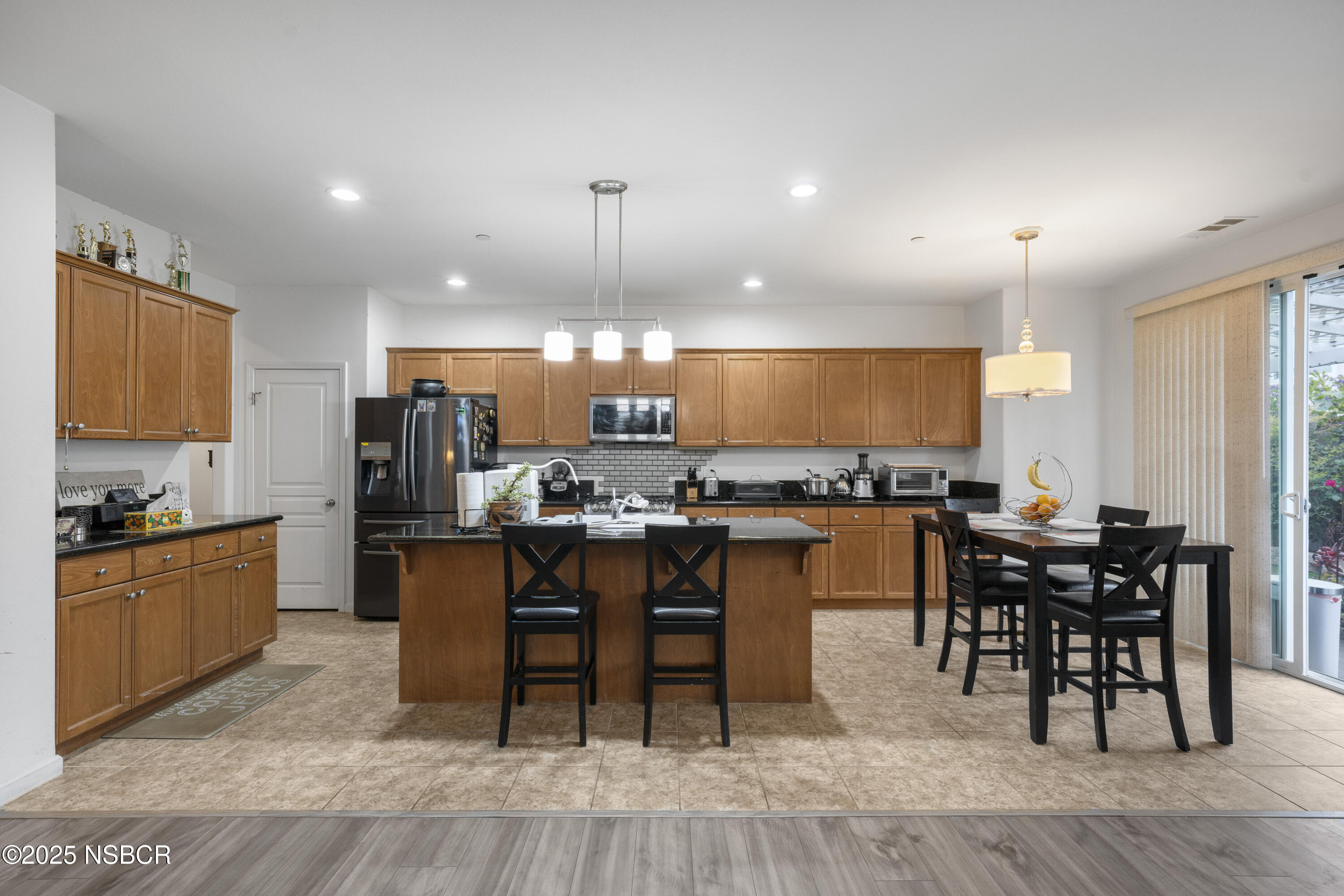 1033 Conception Drive Lompoc, CA 93436 - Photo 7 of 18 a kitchen with stainless steel appliances kitchen island granite countertop a table chairs sink and cabinets