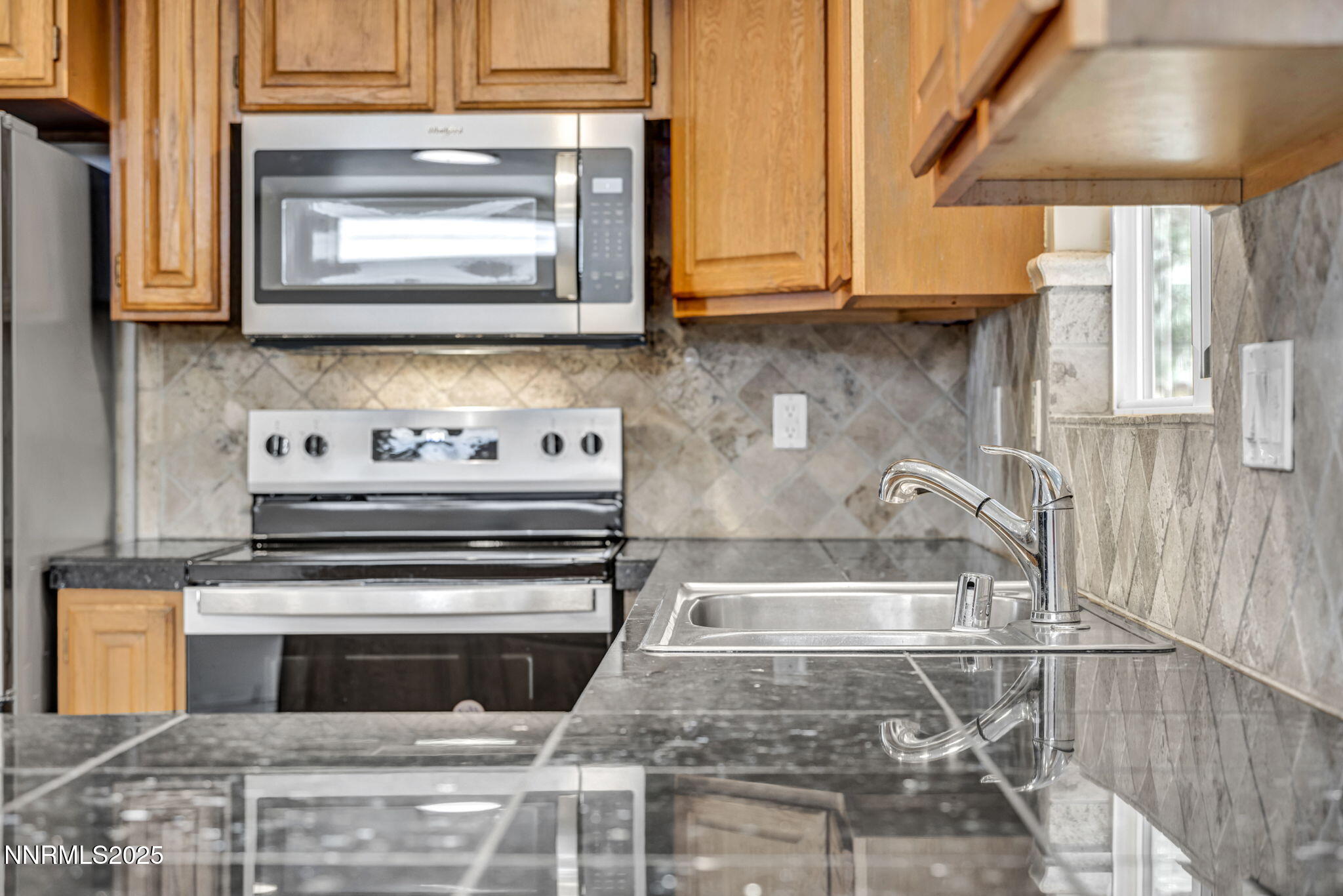 1735 Carlin Street Reno, NV 89503 - Photo 65 of 73 a kitchen with granite countertop a stove and a microwave