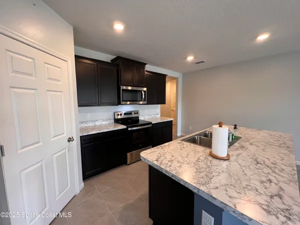 a kitchen with stainless steel appliances granite countertop a sink refrigerator and stove