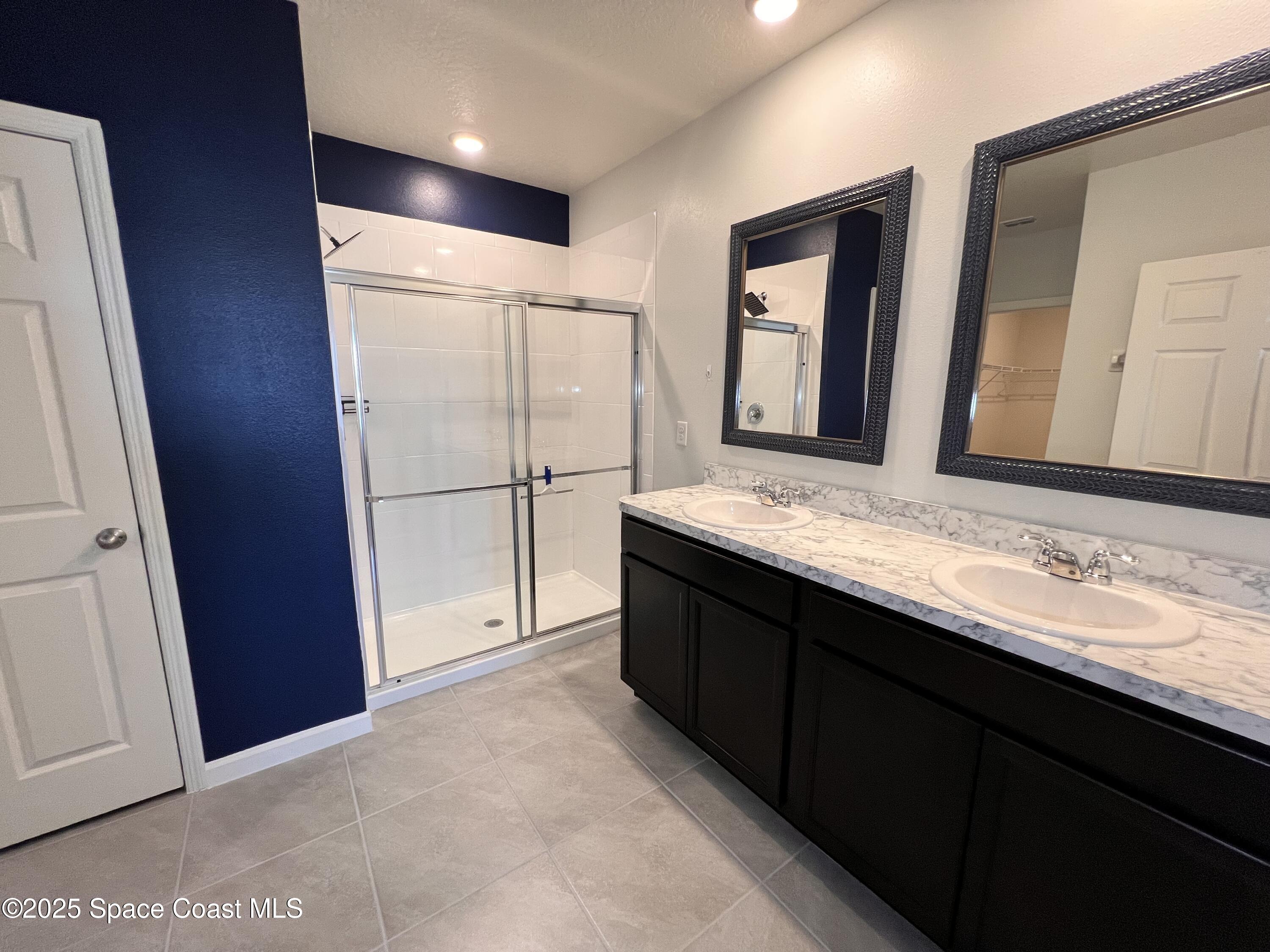 4871 Talbot Boulevard Cocoa, FL 32926 - Photo 22 of 25 a bathroom with a double vanity sink and mirror