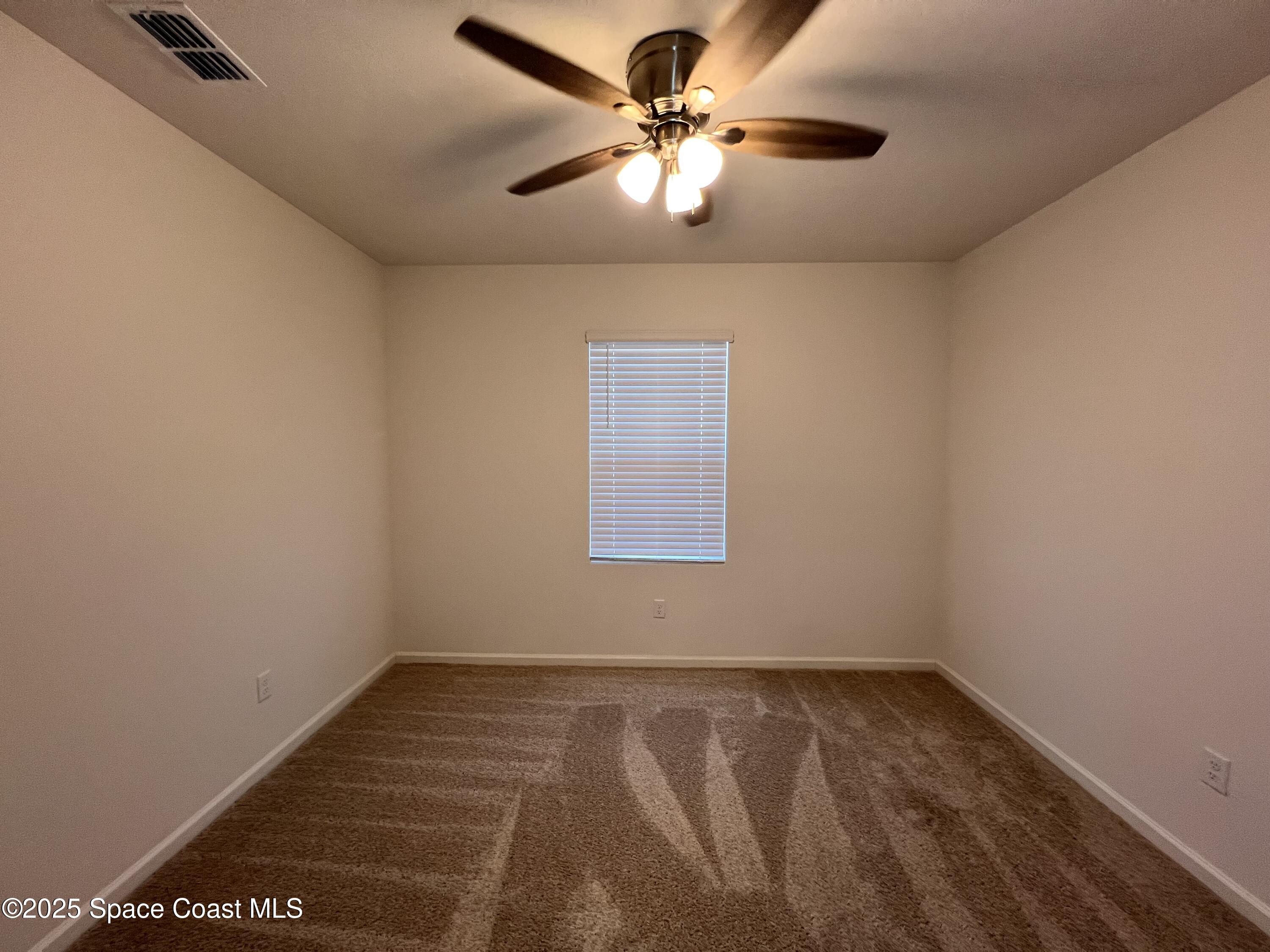 4871 Talbot Boulevard Cocoa, FL 32926 - Photo 9 of 25 an empty room with a window and a fan