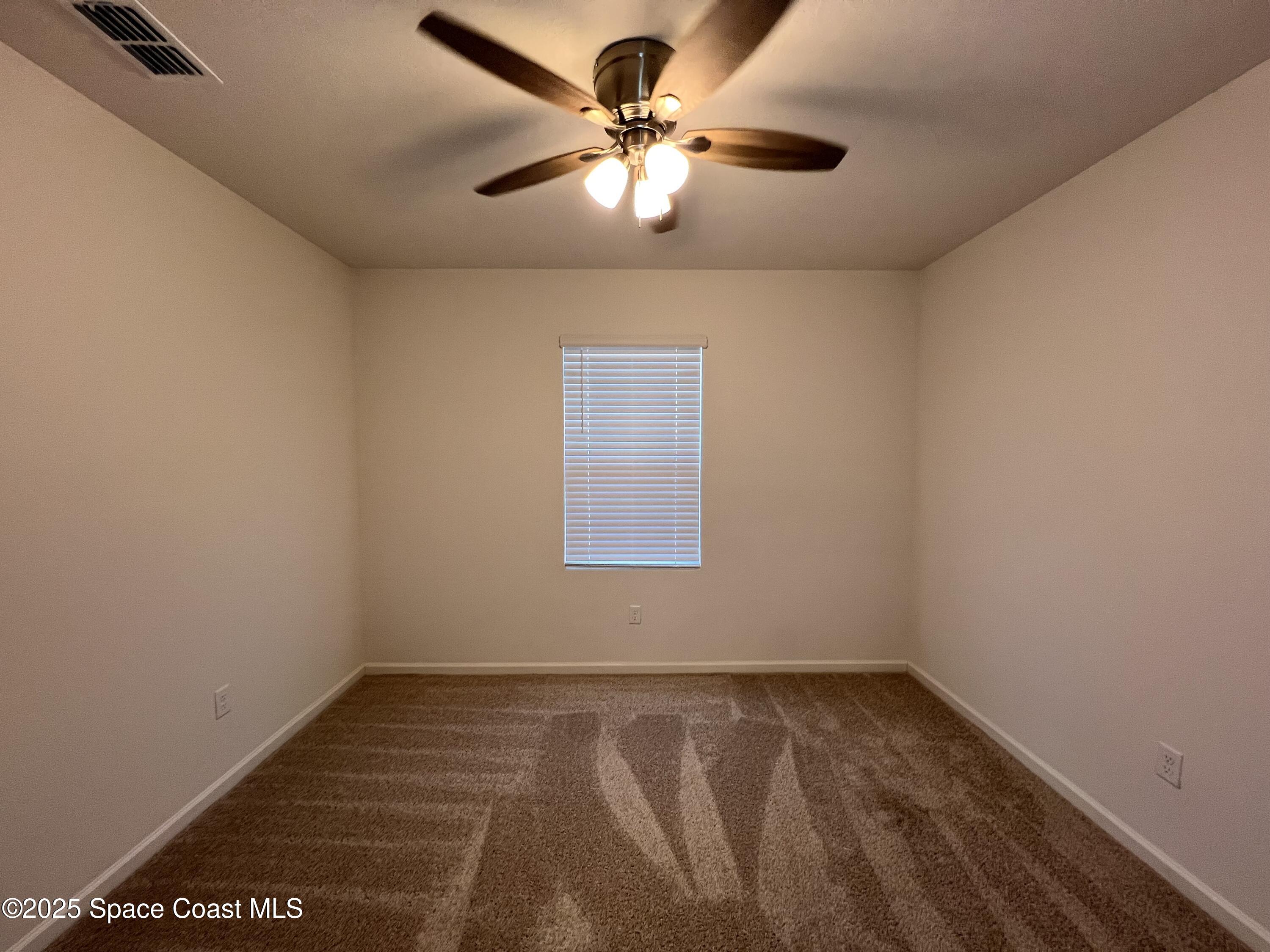 4871 Talbot Boulevard Cocoa, FL 32926 - Photo 10 of 25 an empty room with a window and a ceiling fan
