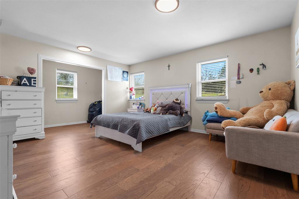 145 Lawson Road Mesquite, TX 75181 - Photo 13 of 31 a bedroom with a bed and wooden floor