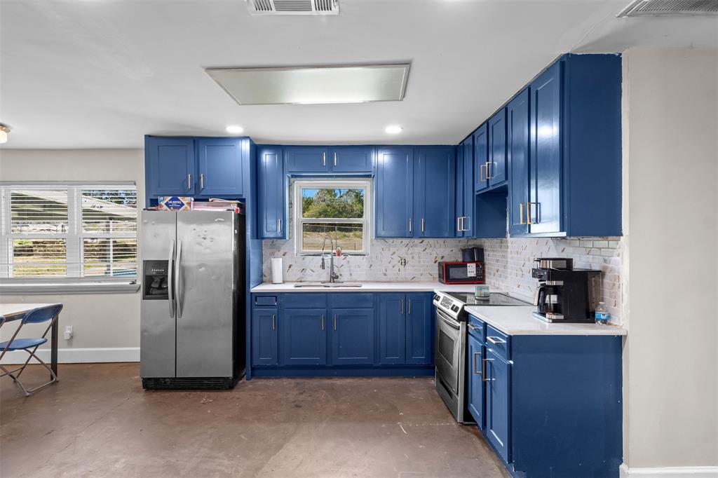 145 Lawson Road Mesquite, TX 75181 - Photo 6 of 31 a kitchen with stainless steel appliances granite countertop wooden cabinets a refrigerator a sink a stove a dining table and chairs