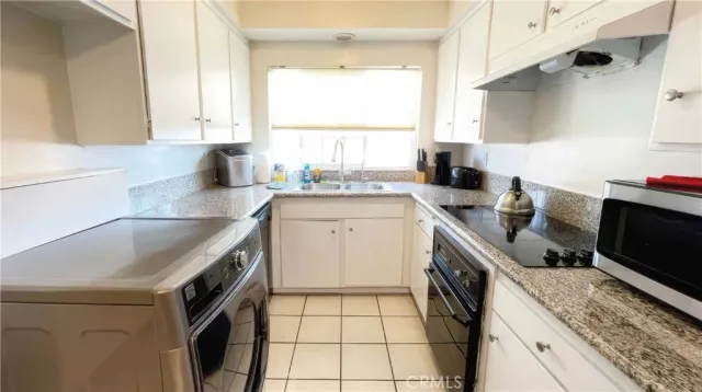 a kitchen with a sink stove top oven and cabinets