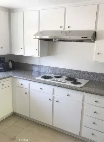 a kitchen with granite countertop white cabinets and a sink