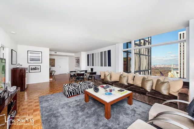 a living room with furniture a rug and a flat screen tv