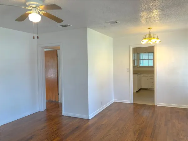 a view of a room with wooden floor and a ceiling fan