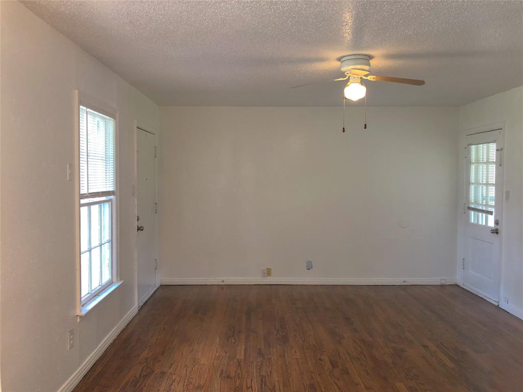 527 Euclid Street Cleburne, TX 76033 - Photo 3 of 8 Empty room with dark hardwood / wood-style floors, plenty of natural light, and ceiling fan