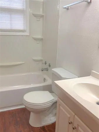 a white toilet and tub next to a window