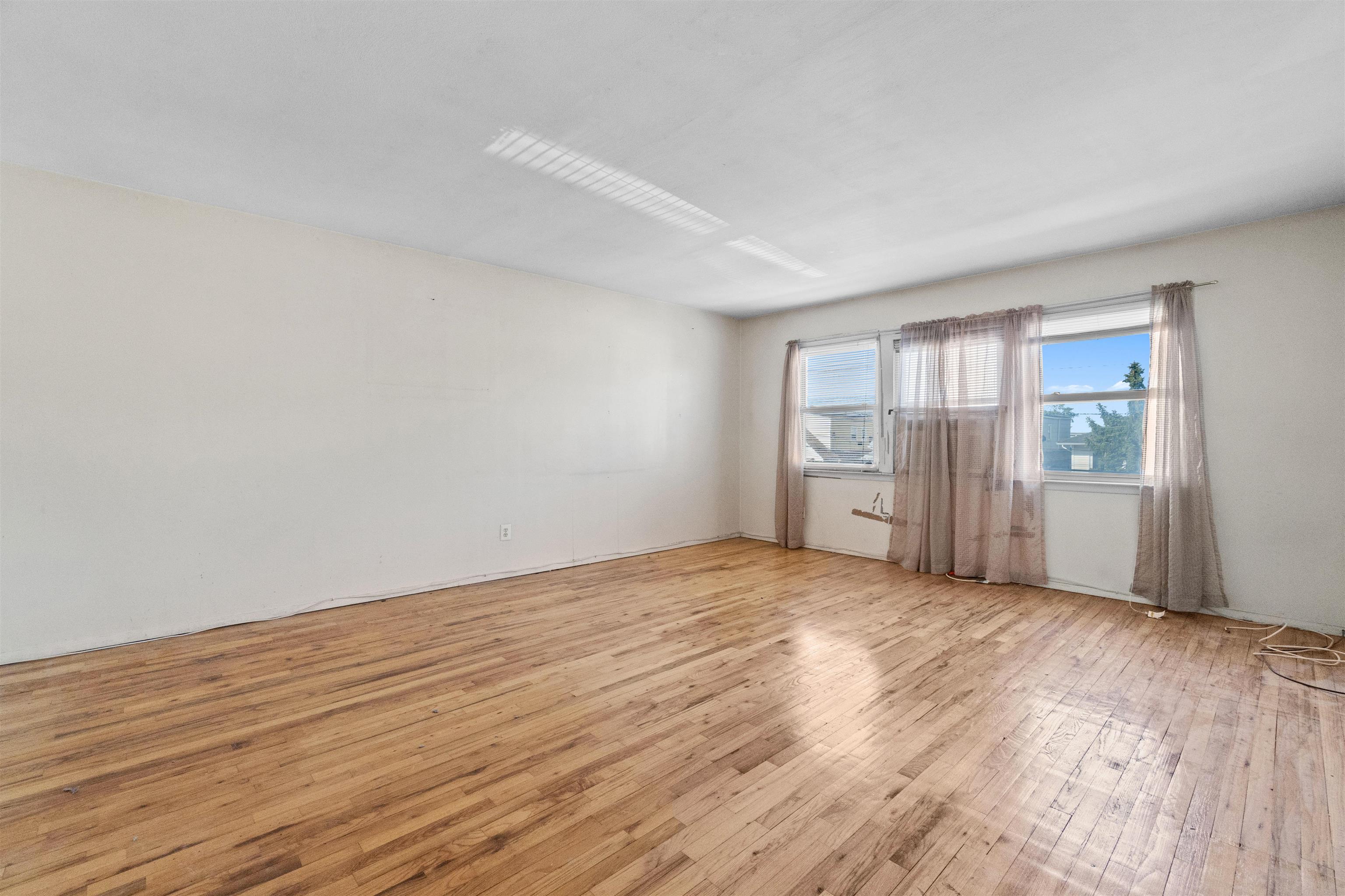 13 Crossgate Road Jersey City, NJ 07305 - Photo 12 of 36 a view of an empty room with wooden floor and a window