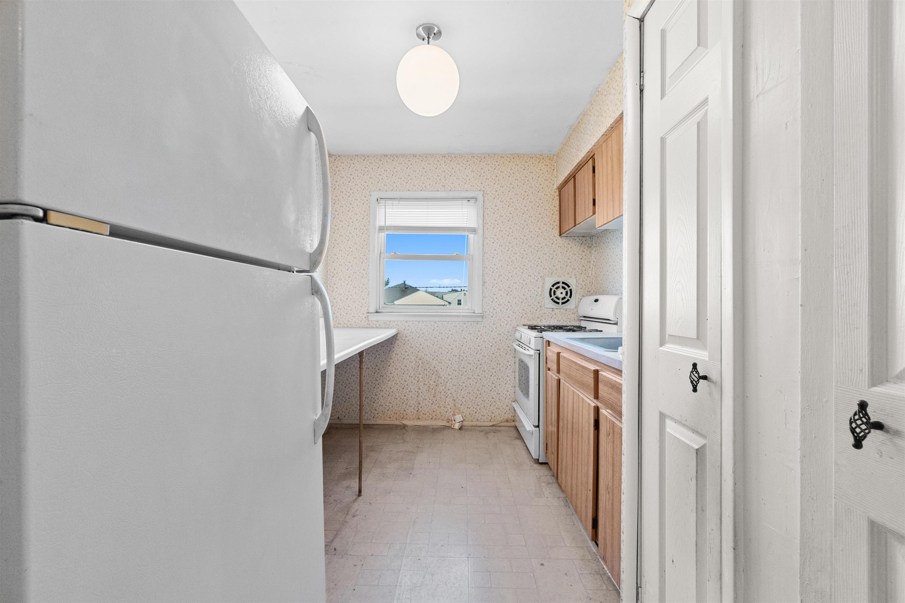 13 Crossgate Road Jersey City, NJ 07305 - Photo 14 of 36 a kitchen with a sink and refrigerator