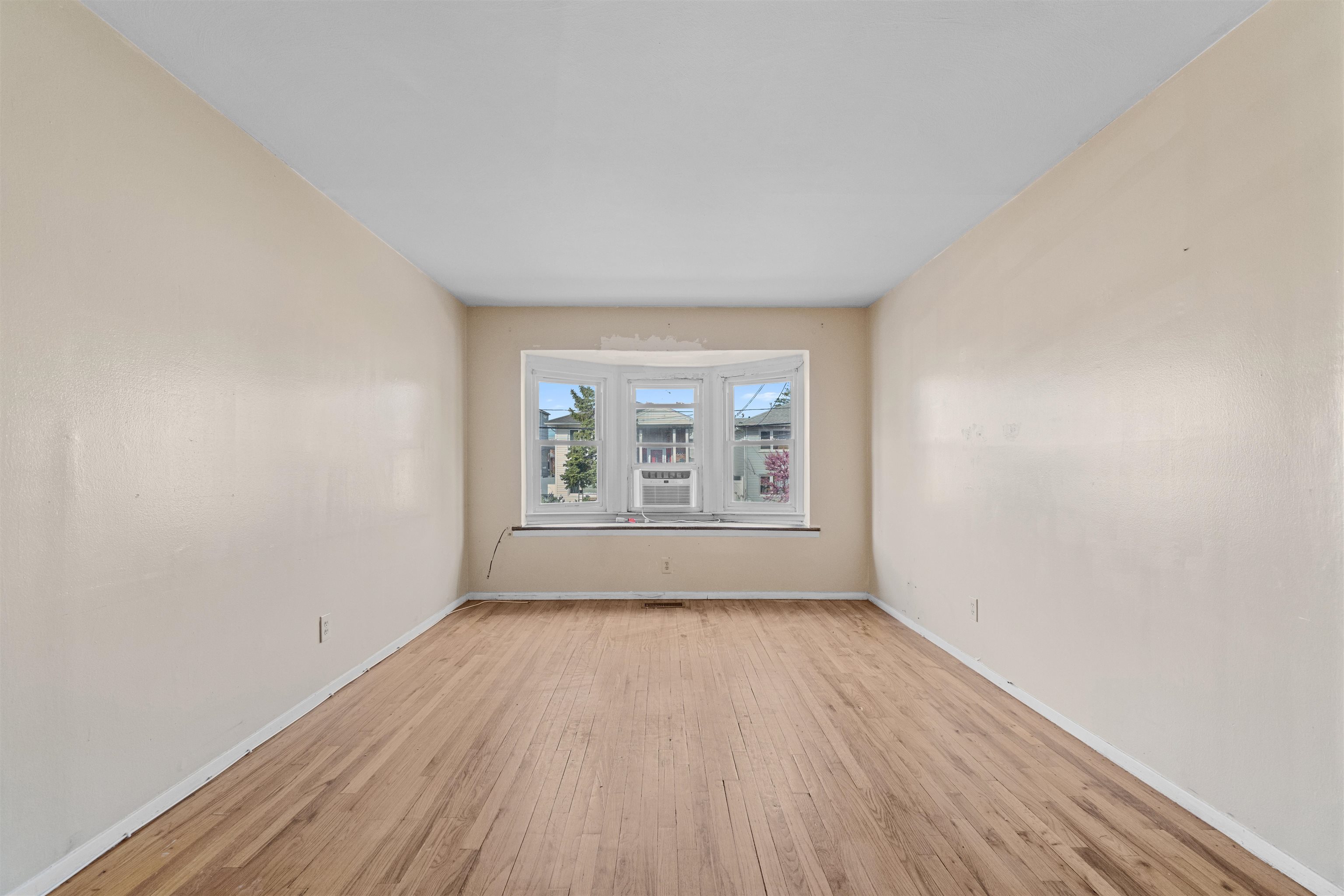 13 Crossgate Road Jersey City, NJ 07305 - Photo 3 of 36 an empty room with wooden floor and windows