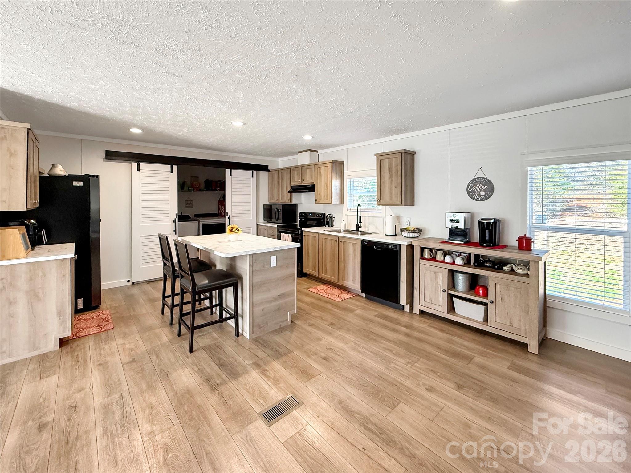 264 Fairchase Circle Stony Point, NC 28678 - Photo 8 of 24 a kitchen with stainless steel appliances kitchen island granite countertop a stove top oven a sink a dining table and chairs