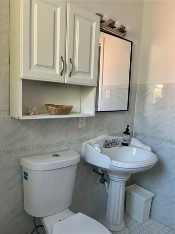 a bathroom with a toilet sink and mirror