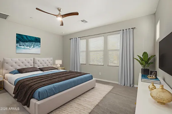 a bedroom with a large bed and a chandelier