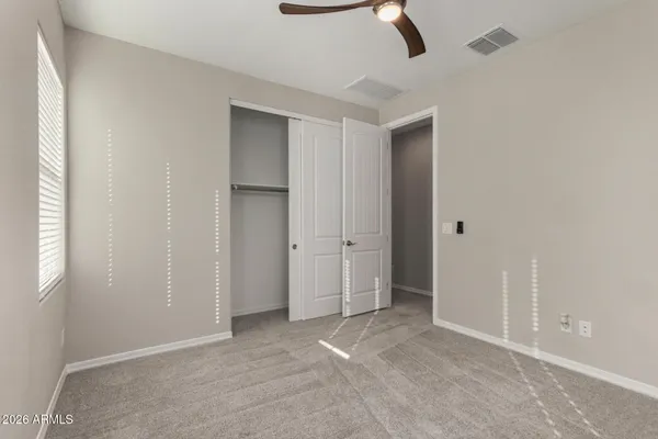 an empty room with closet and windows