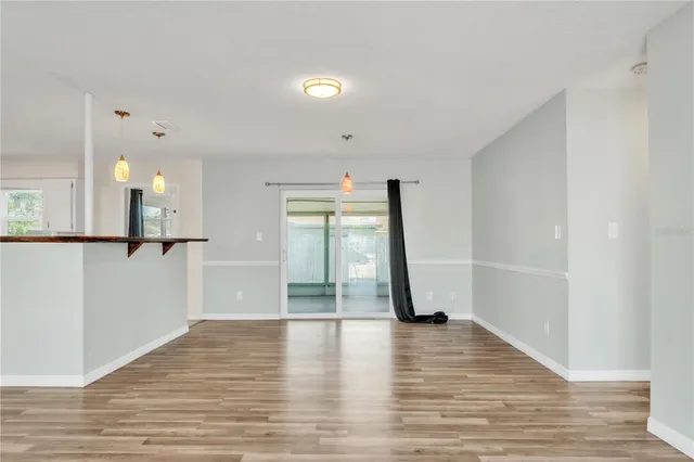 a view of empty room with wooden floor and window