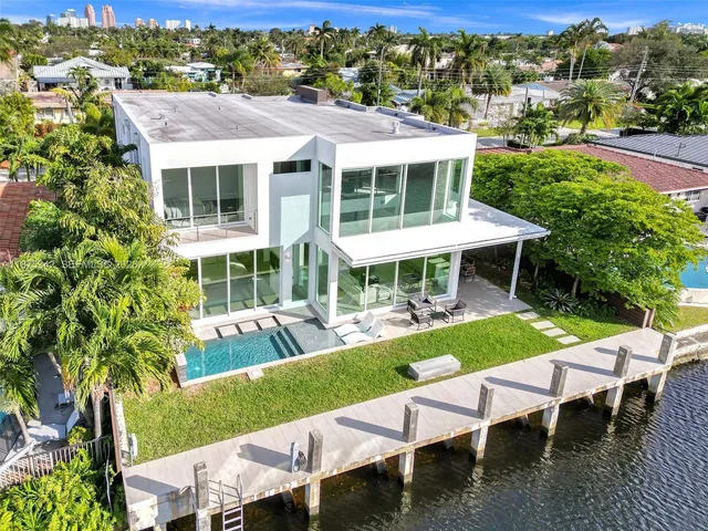 a front view of a house with a yard and potted plants
