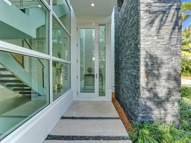 a large white kitchen with a large window and stainless steel appliances