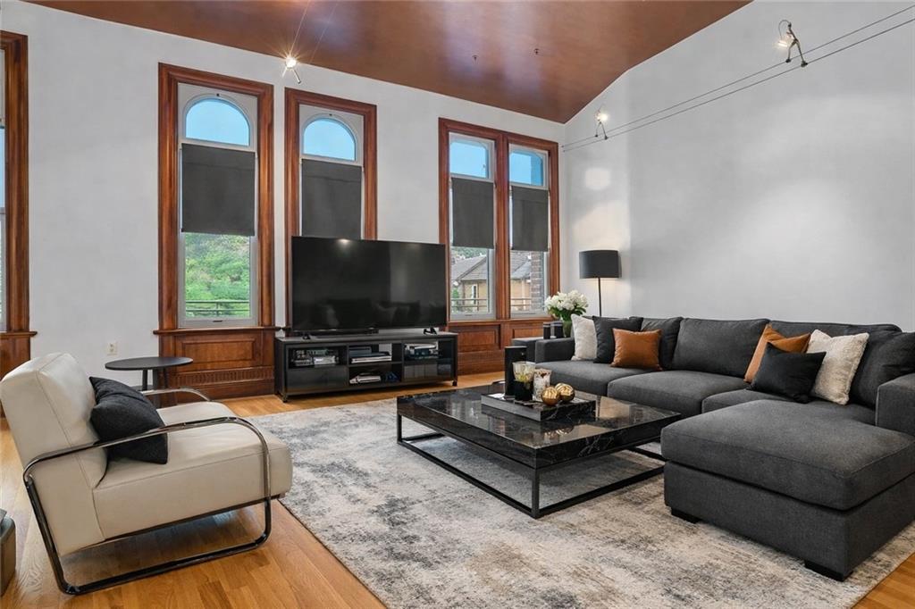 1 Pius Street, Unit B1 Pittsburgh, PA 15203 - Photo 13 of 45 a living room with furniture a large window and a flat screen tv