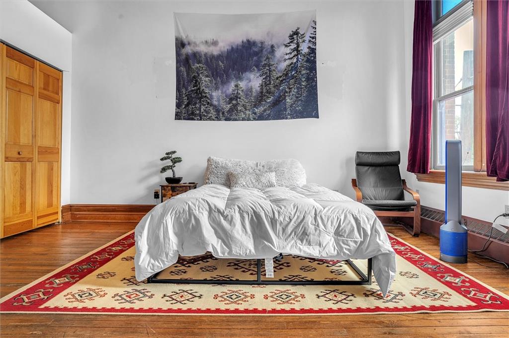 1 Pius Street, Unit B1 Pittsburgh, PA 15203 - Photo 21 of 45 a bedroom with a bed and wooden floor