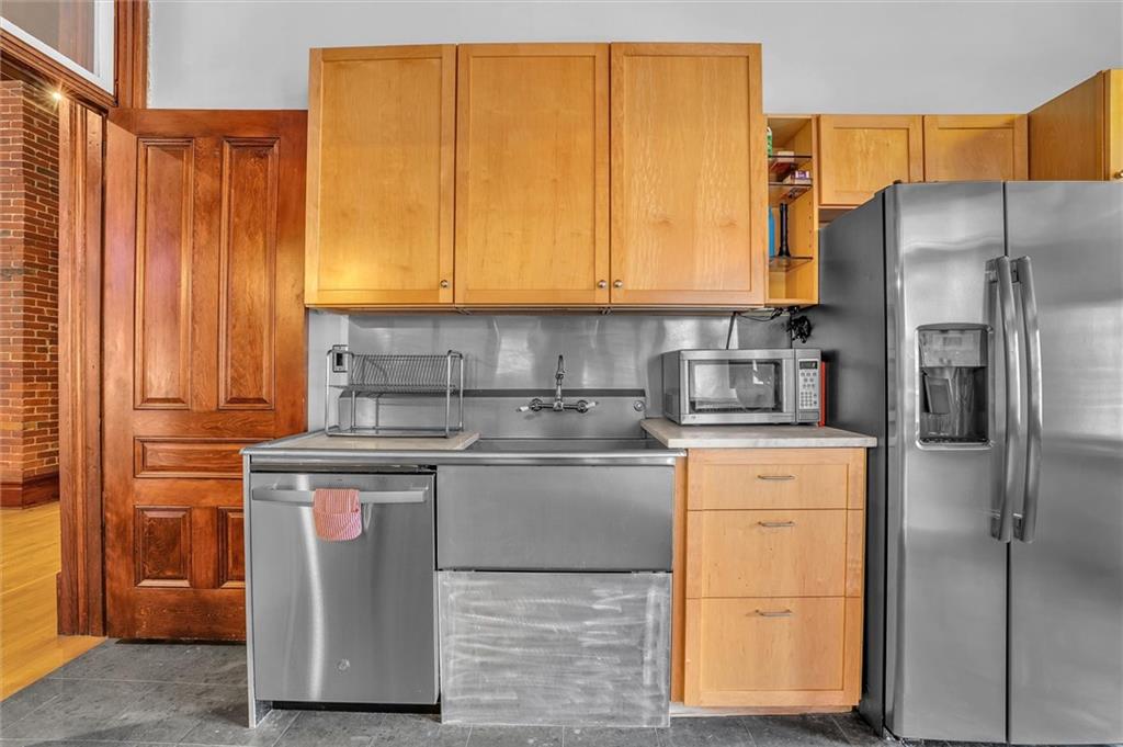 1 Pius Street, Unit B1 Pittsburgh, PA 15203 - Photo 7 of 45 a kitchen with stainless steel appliances granite countertop a refrigerator a stove and a sink with cabinets
