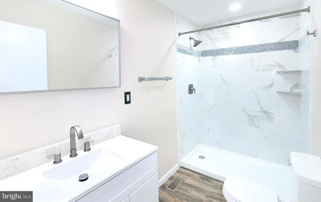 a bathroom with a sink a toilet and shower