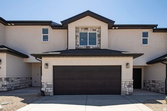 668 East Fiddlers Canyon Road, Unit 24 Cedar City, UT 84721 - Photo 1 of 21 View of front of property featuring stone siding, stucco siding, concrete driveway, and a garage