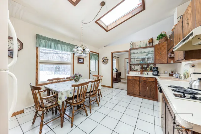 a kitchen with stainless steel appliances a table and chairs in it