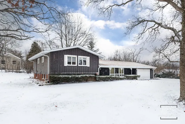 a front view of a house with a yard covered in snow